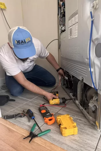 appliance repair technician fixing fridge